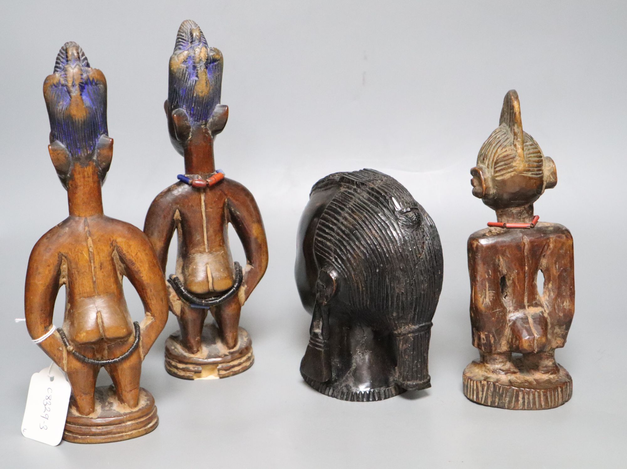 Three Yoruba figural carvings and a carved ebony head, tallest 27cm